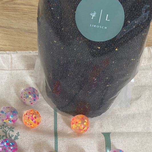 Bio Rapssamen in Plastikverpackung, dazu Baumwollbeutel beschriftet mit LIROSCH, und 12 kleine Bällchen